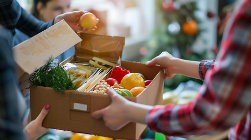 Person receiving a box of fresh produce from another person.