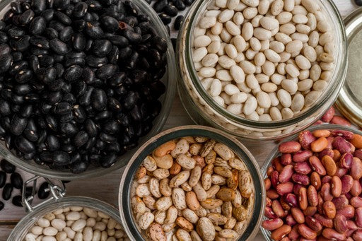 Bowls of different types of beans including black, white, and red beans.