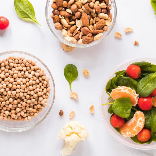 Nuts, beans, and a salad with vegetables on a white background